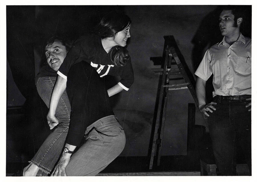 Rehearsal shot of the University of Idaho drama production of 'Carousel.' A man can be seen holding a woman over his shoulder.