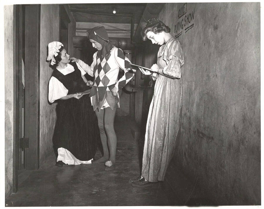 Betty West (maid) and two unidentified actors wait backstage during the University of Idaho drama production of 'Twelfth Night.'