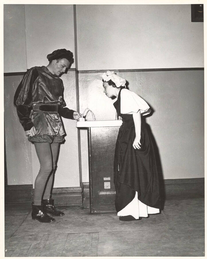 Betty West (maid) and an unidentified actor wait backstage during the University of Idaho drama production of 'Twelfth Night.'