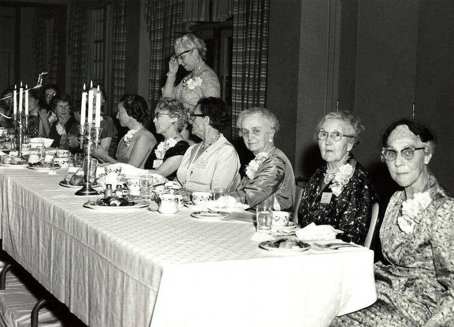 Alumnae members of Gamma Phi Beta sit at the head table during the 50th anniversary dinner for Gamma Phi Beta sorority. Photographer Hutchson Studio, Moscow, ID