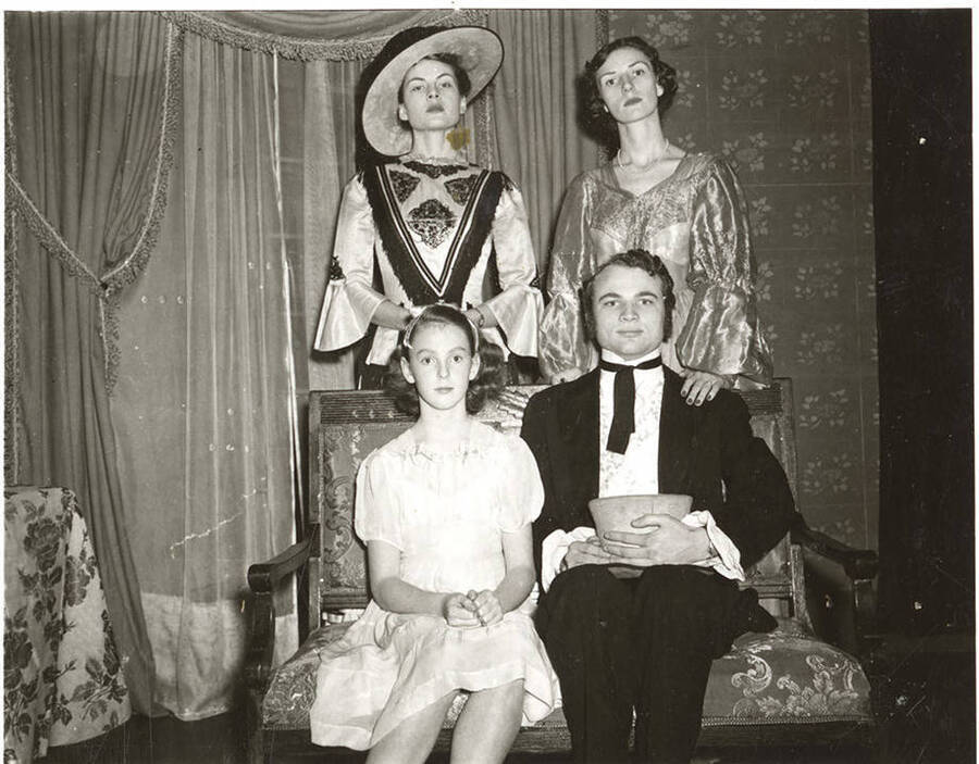 The University of Idaho drama production of 'Uncle Tom's Cabin.' Individuals identified as listed: Standing: Jo Anne Elam as Ophelia, Patricia Jordon as Marie St. Clare; seated: Nancy Buchanan as Eva and Maurice Paulsen as St. Clare