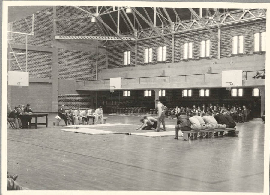 Unnamed wrestlers in the on-the-ground position during a match at Memorial Gymnasium.