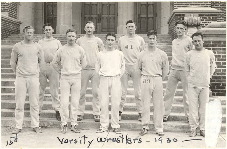 The 1930 Idaho varsity Wrestling team stands at the steps of the Memorial Gymnasium for a team photograph.