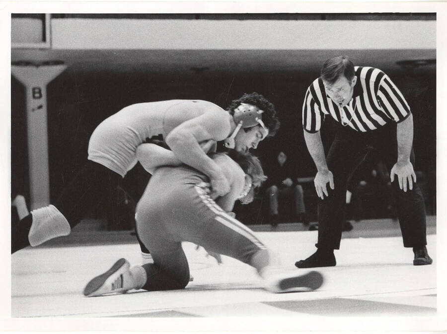 Two unnamed wrestlers grapple in the Memorial Gymnasium.
