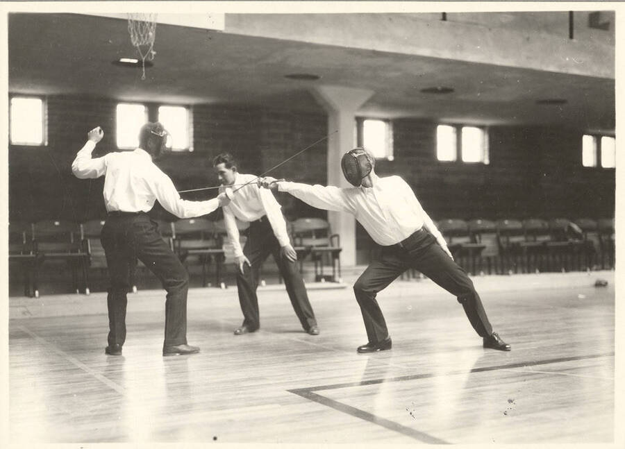 An Idaho fencer ripostes while the other tries to evade a touch during a match in Memorial Gymnasium.