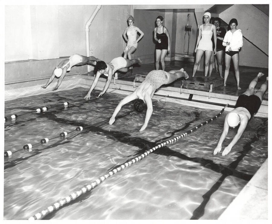 Idaho women's swimmers dive into the pool during a 1961 meet.