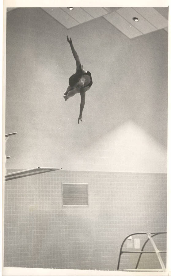 An unidentified women's diver twirls through the air during practice in the Swim Center.