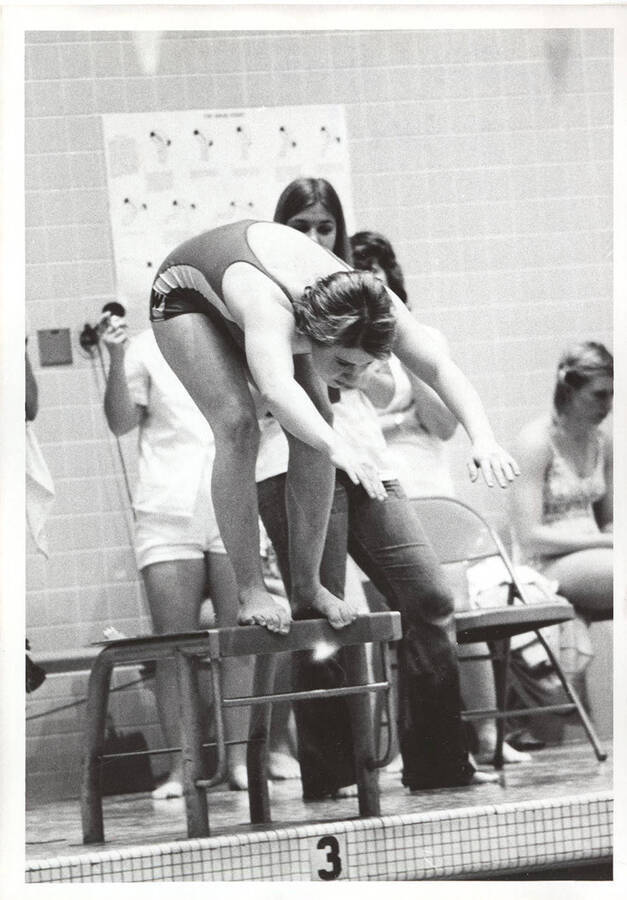 A Washington State women's swimmer prepares to leave the starting block.