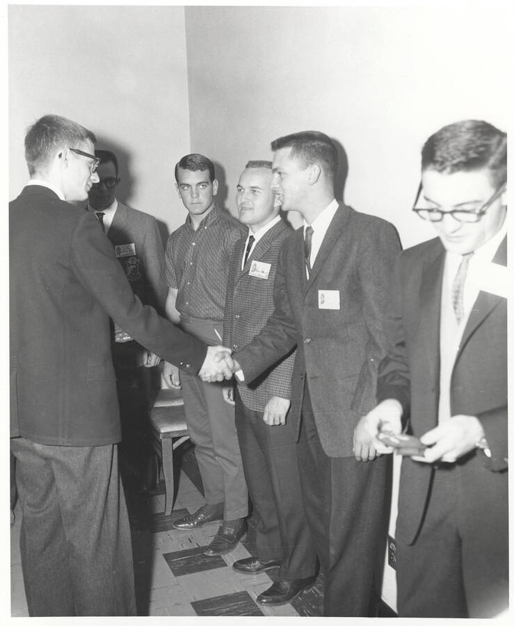 Attendees to the 37th National Convention of the Intercollegiate Knights, a national honorary service organization, network in a hallway.