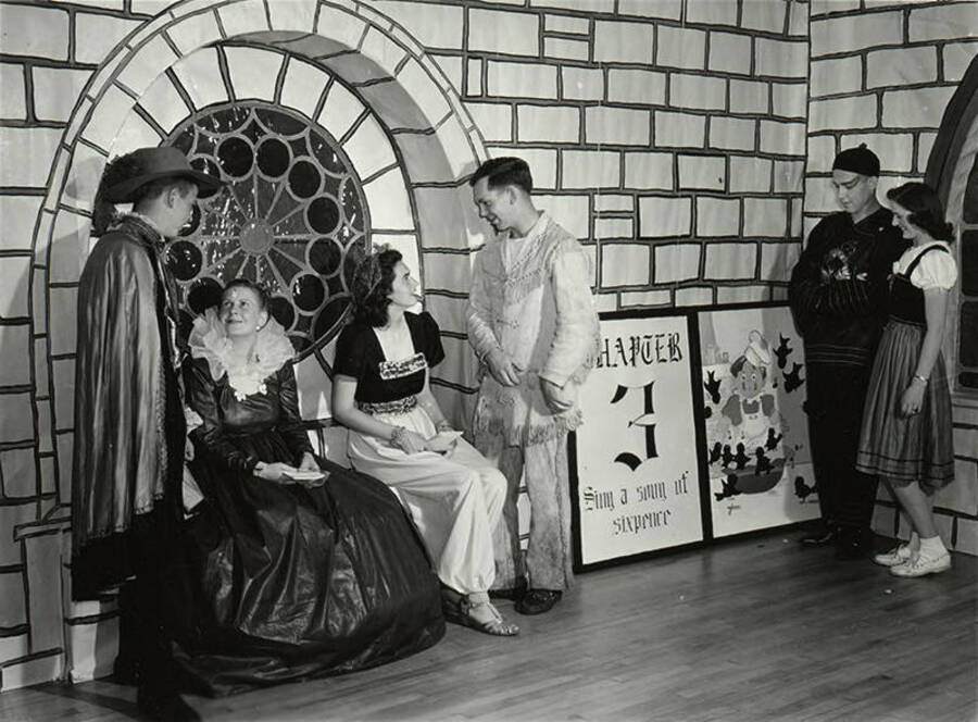Couples sit and talk in a theme-decorated room during the Storybook Ball.