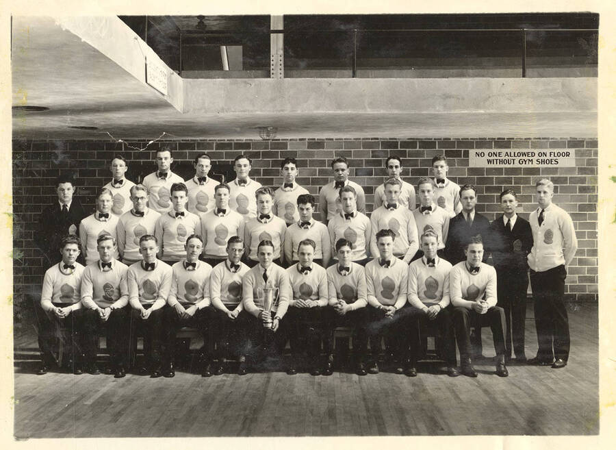 A group photo of the Intercollegiate Knights, a national honorary service organization, standing in the Memorial Gymnasium. Individuals are identified on the photograph mount.
