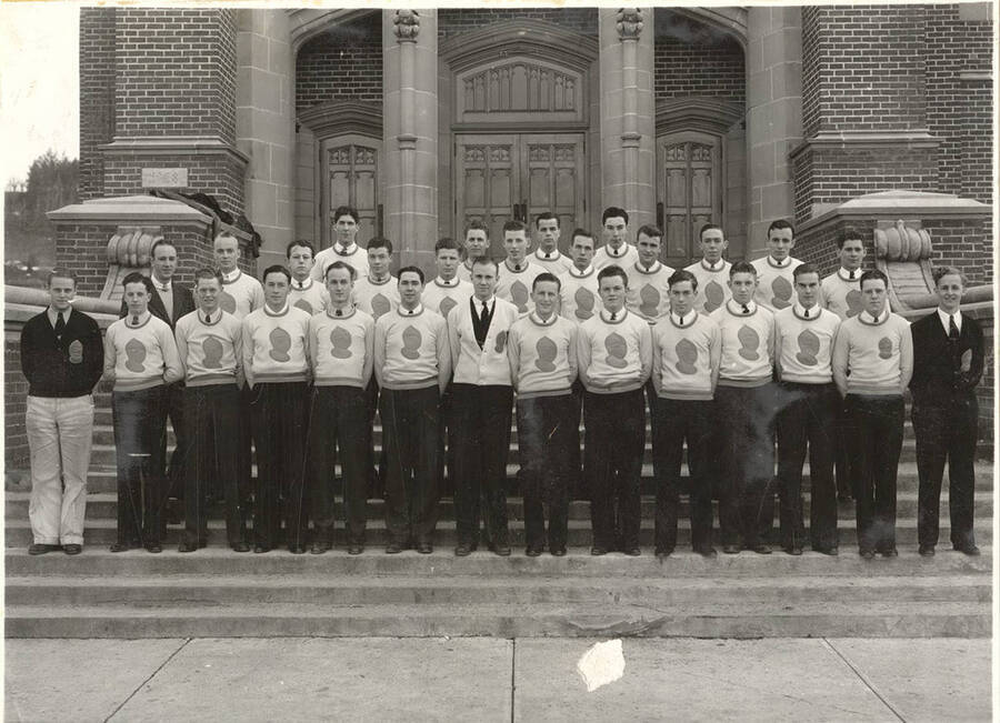 A group photo of the Intercollegiate Knights, a national honorary service organization, standing on the front steps of the Memorial Gymnasium.