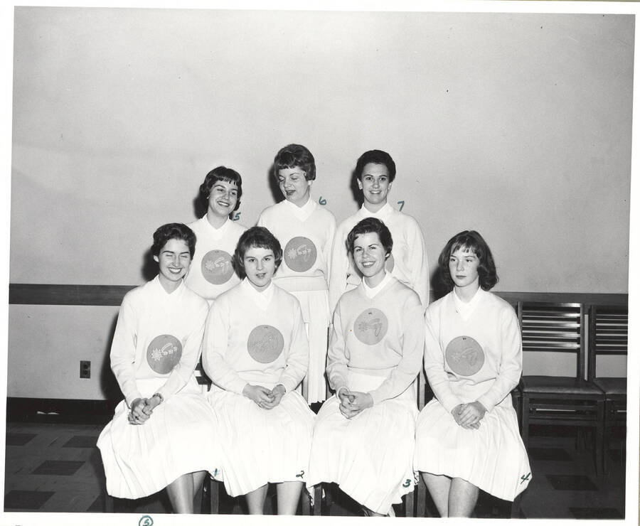 A group photo of new members of the Spurs, a national honorary service organization, sitting in the Administration Building. Individuals identified from left to right. Front: Diane Heller, Rowena Eikum, Bette Vickerman, Cooki Goodman; Back: Angie Arrien, Mary Elise Winegar, Judy Libby