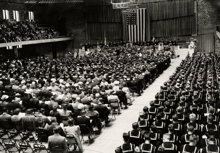 The audience and graduates sit facing the stage in the Memorial Gym during the 1943 Commencement ceremony.
