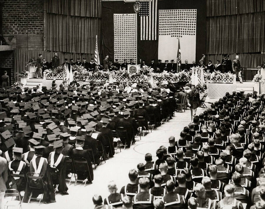 Graduates sit facing the stage during the 1943 Commencement ceremony held in the Memorial Gym.