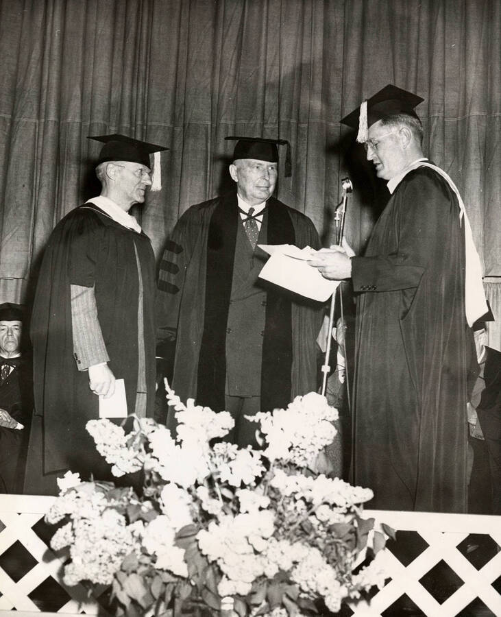 Stanly A. Easton receiving an honorary Doctor of Laws degree from Dean A.W. Fahrenwald (School of Mines) and University of Idaho president Jesse Buchanan during the 1950 Commencement ceremony. Easton was the president of the Bunker Hill and Sullivan Mining and Concentrating Co.