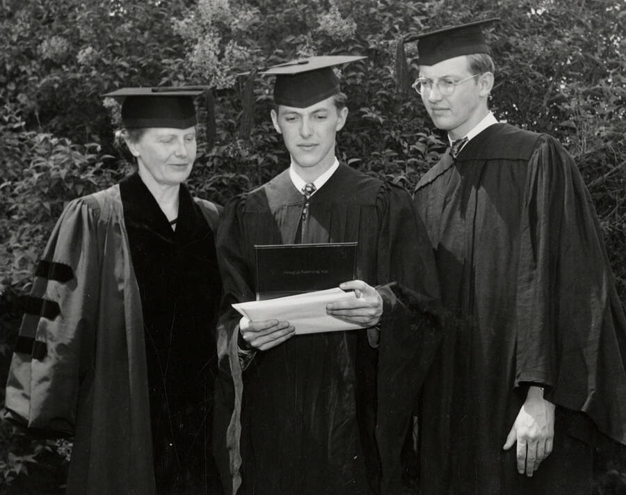 Maude Cosho Houston, a member of Board of Regents, with her sons Louis (left) receiving a Bachelor of Arts degree and John receiving a Bachelor of Science degree during the 1948 Commencement ceremony.