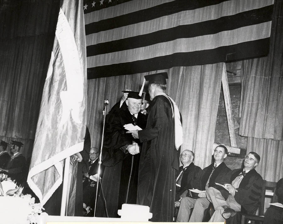 Grover D. Turnbow, the president of the International Dairy Association and a University of Idaho agriculture graduate, receiving an honorary Doctor of Science degree during the 1949 Commencement ceremony.