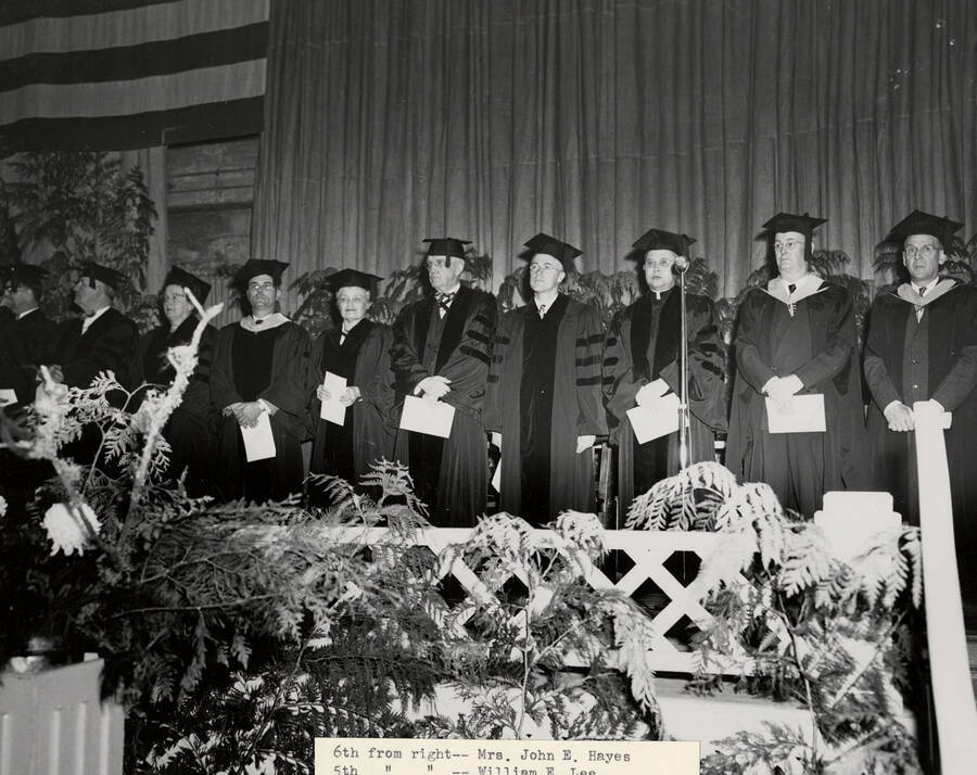 Registrar D. D. DuSault, Dean Lattig, Urban Schmitt, Tutus G. LeClair, William E. Lee, and Mrs. John E. Hayes stand together on stage for the 1951 Commencement ceremony.