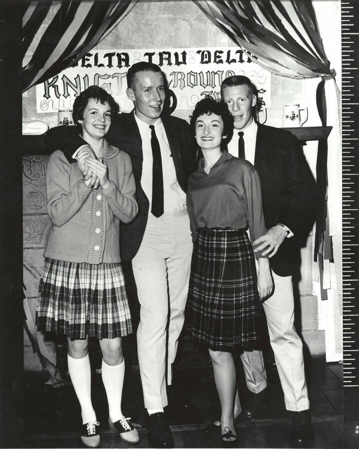 Two couples pose for a photograph at the Delta Tau Delta dance.