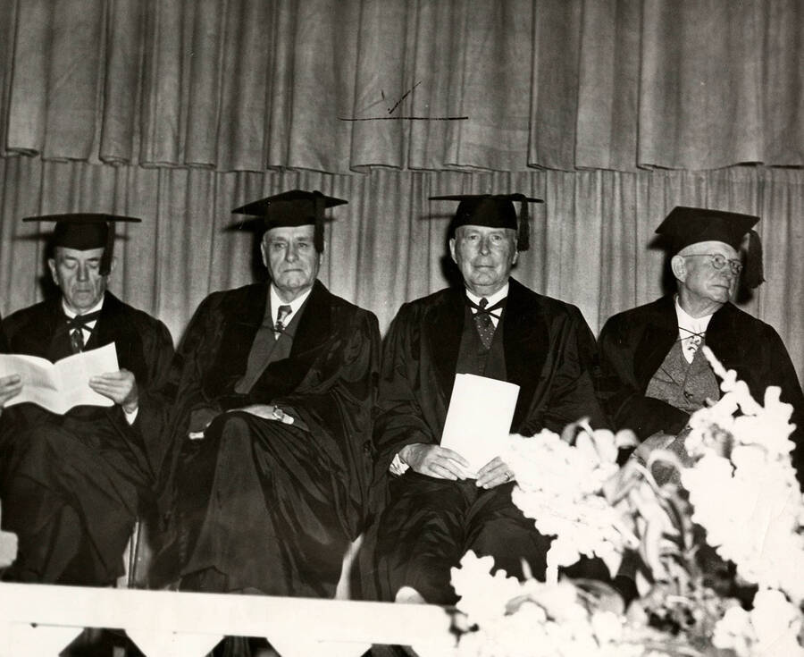 Dean Edward John Iddings, Harry W. Morrison, Stanly A. Easton, and James W. Girard sit together on stage during the 1950 Commencement ceremony.