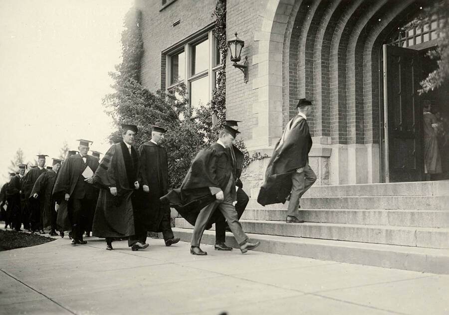 the 1924 Commencement procession enters the Administration Building. Professor Dale mounting the steps, Governor Moore (foreground) and University of Idaho President Alfred A. Upham. Prince Gelasio Caetani (facing camera) and Stanly Easton