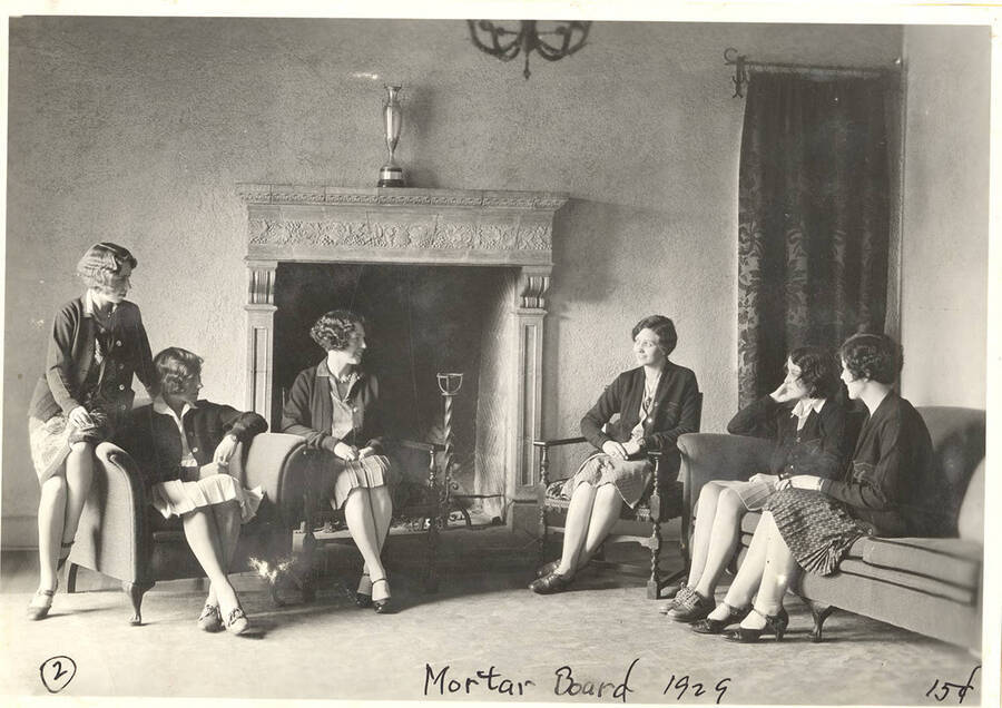 Six members of Mortar Board, a national honorary society for senior women, sit by a fireplace.