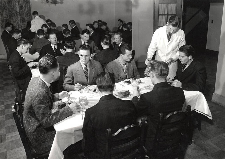 The men of Sigma Nu sit down for dinner as a group.