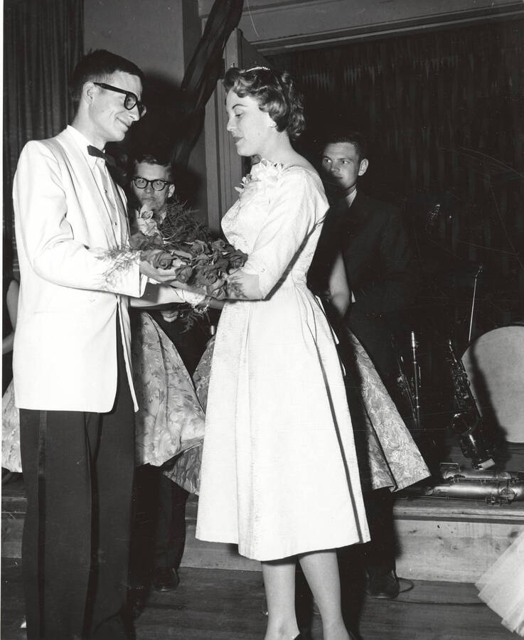 A contestant for queen accepts a bouquet of flowers after being crowned  during the 37th National Convention of the Intercollegiate Knights, a national honorary service organization.