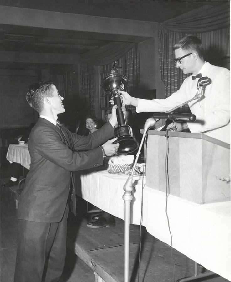 An unidentified attendee of the 37th National Convention of the Intercollegiate Knights, a national honorary service organization, accepts an award in the Student Union Building ballroom.