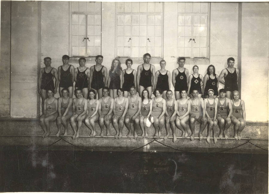 Members of the Helldiver's swimming club pose for a group photograph along the wall by the swimming pool inside Memorial Gymnasium.