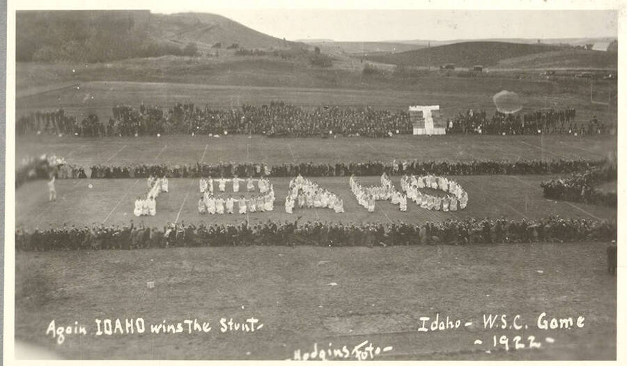 Idaho students participate in the Idaho Stunt at the Harvard Yell Contest during a Football game. Caption reads: Again IDAHO Wins the Stunt, Idaho - W.S.C. game 1922.