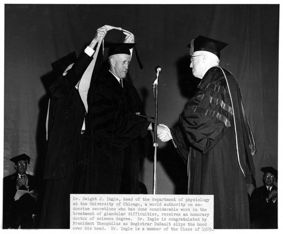 Dr. Dwight J. Ingle receives an honorary Doctor of Science degree from University of Idaho President Donald Theophilus during the 1962 Commencement ceremony. Registrar Donald Dudley DuSault presents the special hood