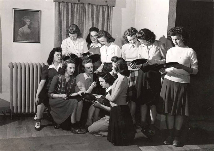 Members of Alpha Chi Omega look at phonograph records in the Alpha Chi Omega living area.