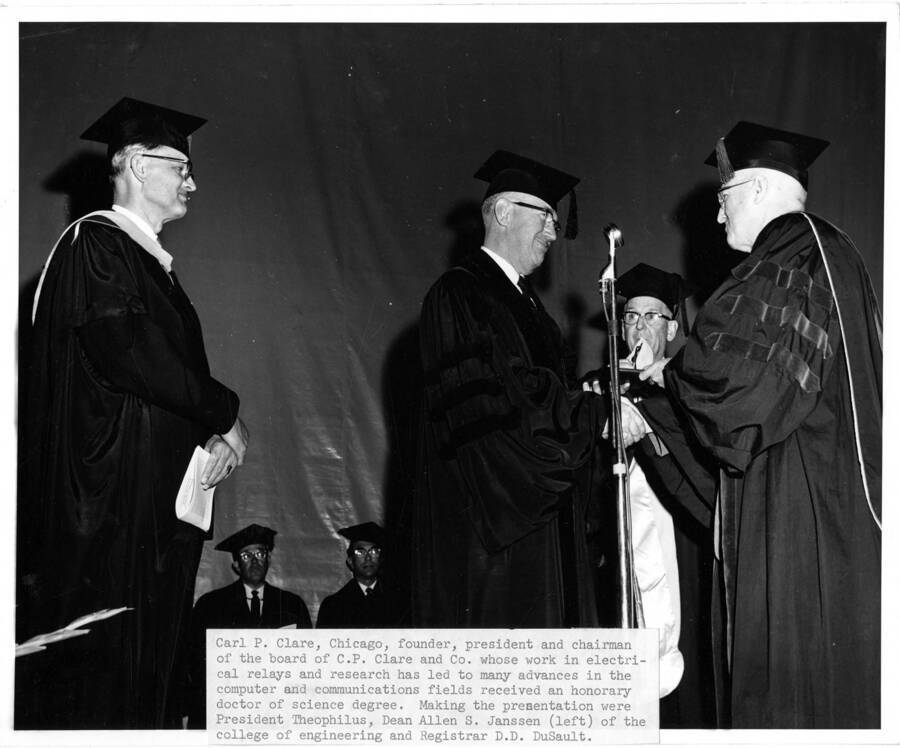 Carl P. Clare receives an honorary Doctor of Science degree from University of Idaho President Donald Theophilus during the 1962 Commencement ceremony. Dean Allen S. Janssen (left) and Registrar Donald Dudley DuSault (behind)