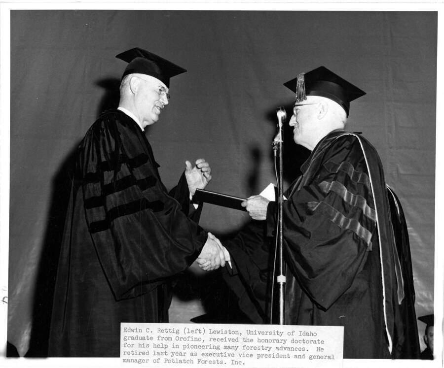 Edwin C. Rettig (left) receives an honorary Doctor of Science degree from University of Idaho President Donald Theophilus during the 1963 Commencement ceremony.