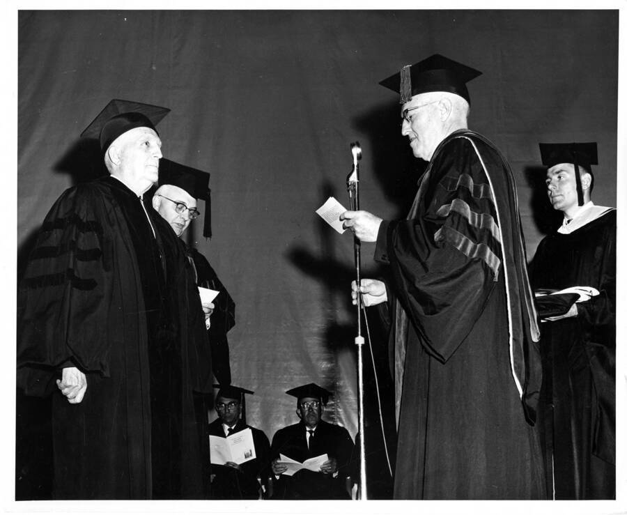 Harold B. Bachman receives an honorary doctorate degree from University of Idaho president D. R. Theophilus during the 1963 Commencement ceremony.