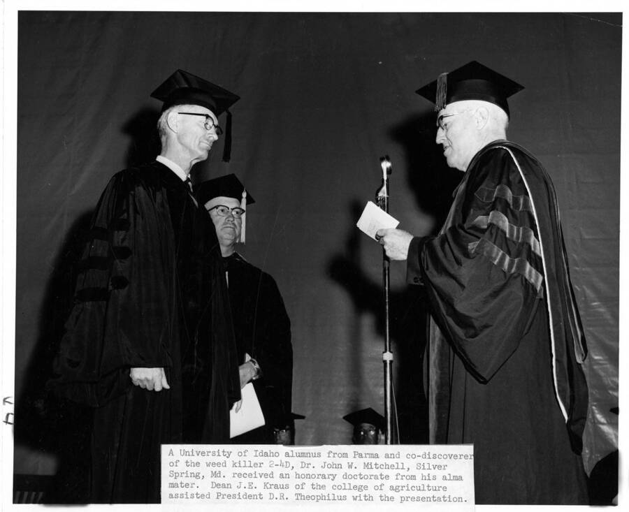 Dr. John W. Mitchell receives an honorary Doctor of Science degree from University of Idaho President Donald Theophilus during the 1963 Commencement ceremony. Dean James E. Kraus assisting
