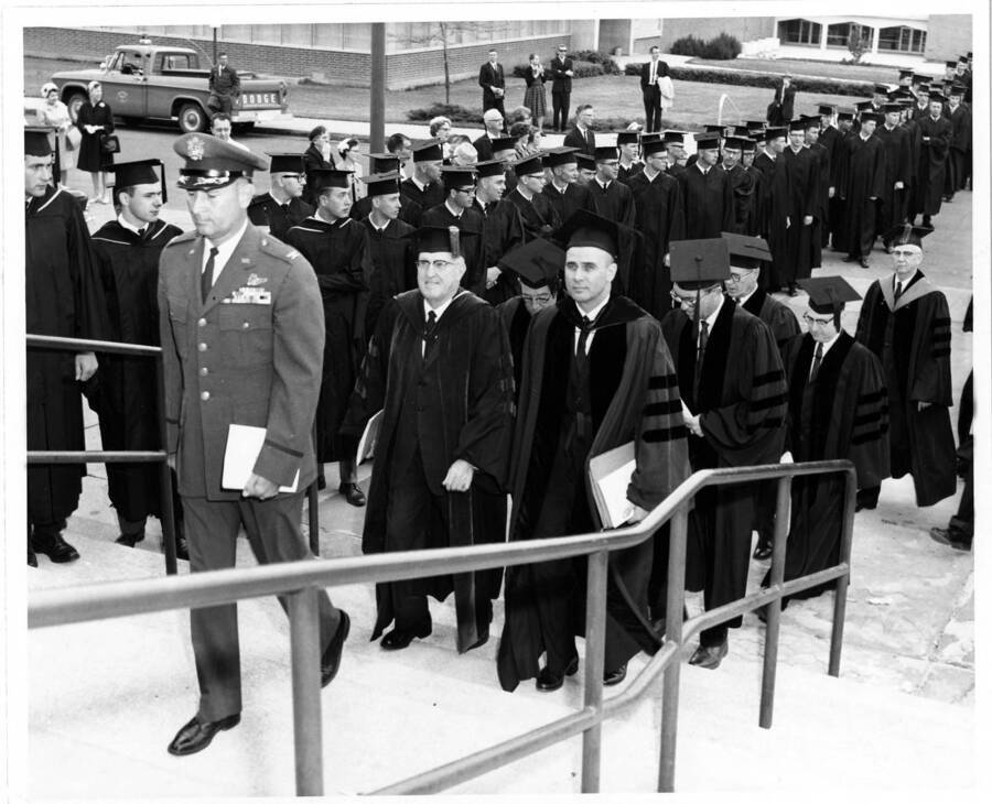 Colonel Robert C. Ogletree, University of Idaho President Donald Theophilus, Regent Elvon Hampton, Regent Curtis Eaton, and Regent John Peacock lead the 1964 Commencement Procession up the steps of the Memorial Gymnasium.