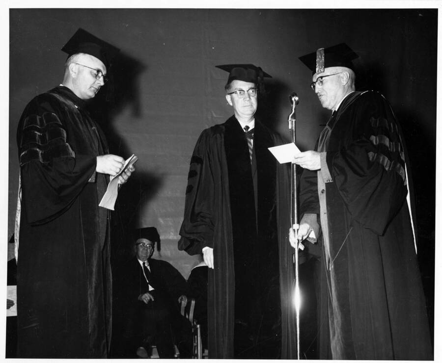 Dr. Lawrence Chamberlain receives an honorary Doctor of Laws degree from University of Idaho President Donald Theophilus during the 1959 Commencement ceremony. Dr. Boyd A. Martin on left