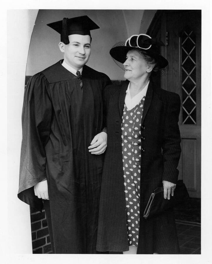 An unidentified graduate and his mother stand together at the Administration Building doors.