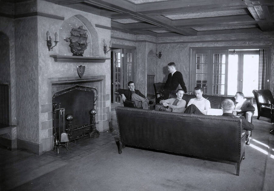 Students sit around the living room/parlor of the Alpha Tau Omega house, located on the northwest corner of Deakin and Idaho Streets.