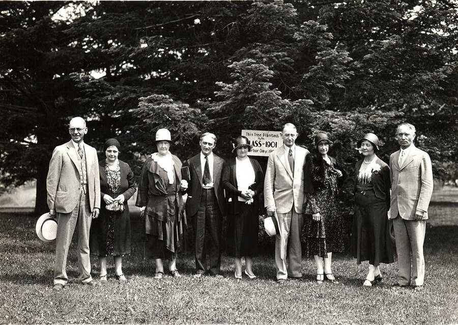 A group photo of members of the class of 1901 gathered in front of the tree they planted in 1900 as part of their 30th reunion.