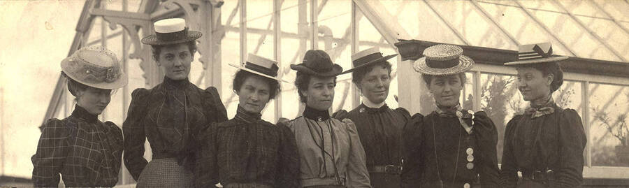 A group portrait of women standing in front of the green house on the Administration Lawn.