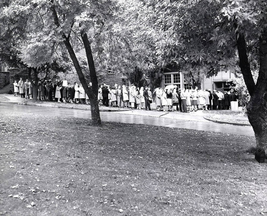 A line of students wait to enter the Women's Gym to register for classes, as seen from the Administration Lawn. The Women's Gym became Art and Architecture South in 1976.