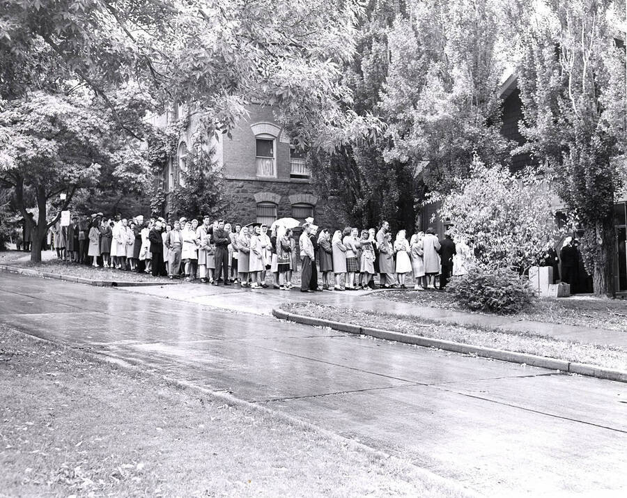 A line of students that is beginning to wrap around the building wait to enter the Women's Gym to register for classes, as seen from the Administration Lawn. The Women's Gym became Art and Architecture South in 1976.