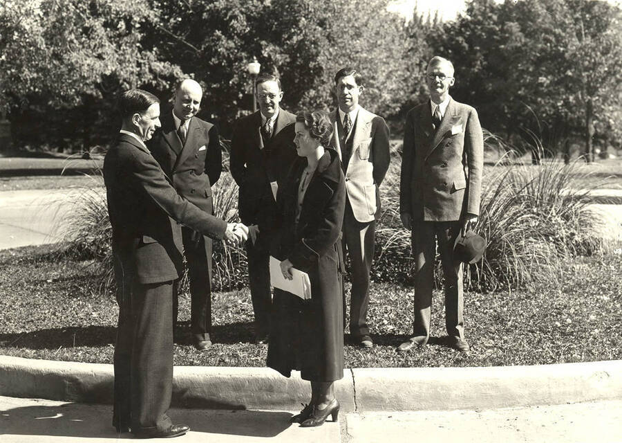 President Mervin G. Neale congratulates Barbara Kathryn on being the first 2000th student to register for classes. Back row pictured left to right: Ed Poulton, Howard David, Louis A. Boas, Rolston Butterfield