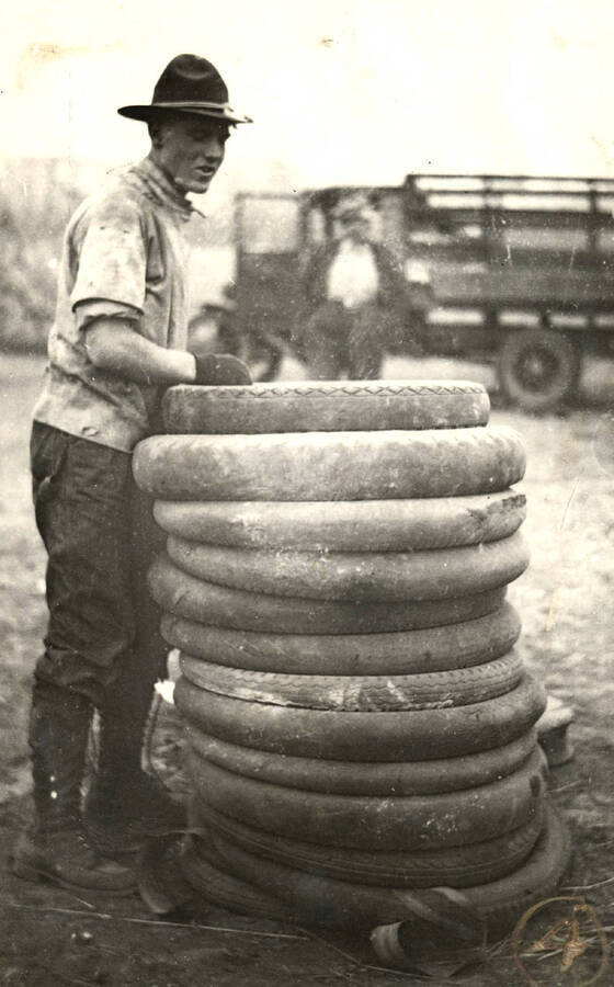 An unidentifed man in a rangers uniform stacks tires as part of preparations for the Homecoming Freshman bonfire.