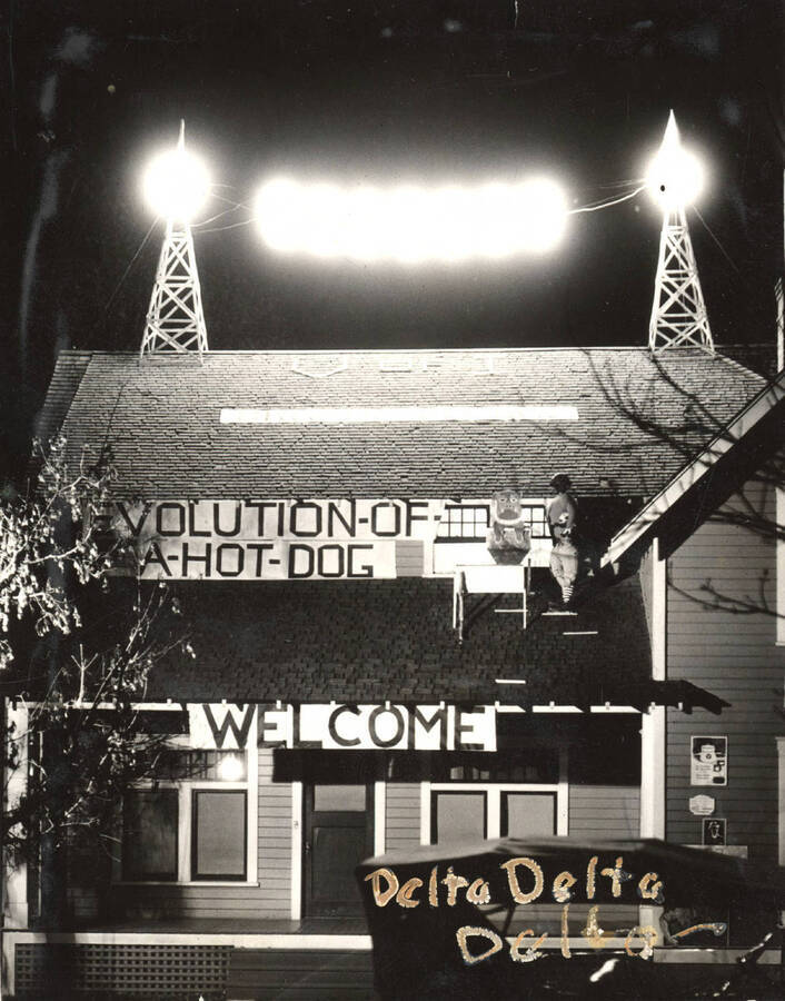 Delta Delta Delta's house decorations feature a light display on the roof and a sign that reads 'Evolution of a hot dog, Welcome.'