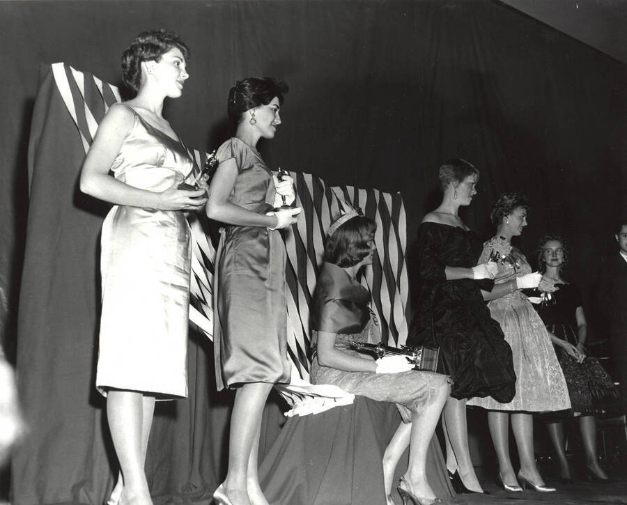 Celeste Jones, Homecoming Queen, and her princesses stand on stage, holding their individual awards. Similar to 084-023